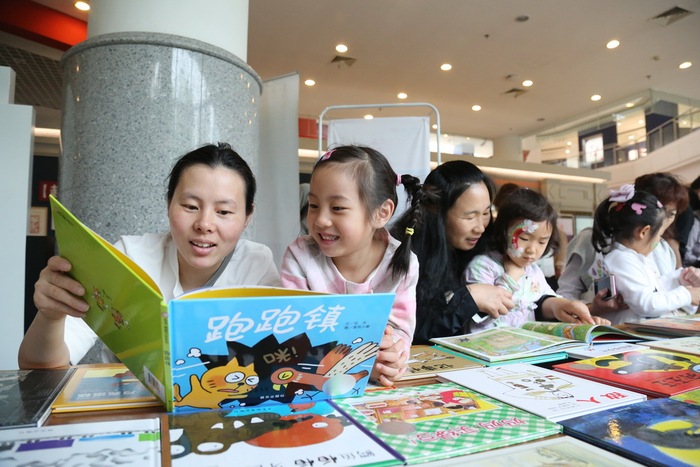 在上海市举办的科学育儿指导公益活动现场,孩子在母亲陪伴下阅读童书。摄影陆嘉辉.JPG