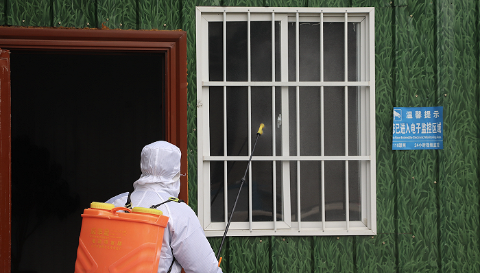 一名防疫人员正在住所附近喷洒消毒液 图片来源：视觉中国(photo:JieMian)
